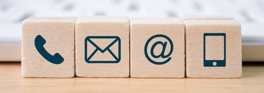 Drewniane klocki z symbolami telefonu, wiadomości e-mail i telefonu komórkowego
